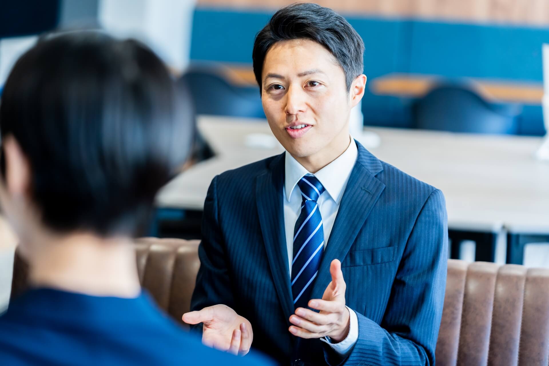 会議で説明をするスーツ姿の男性