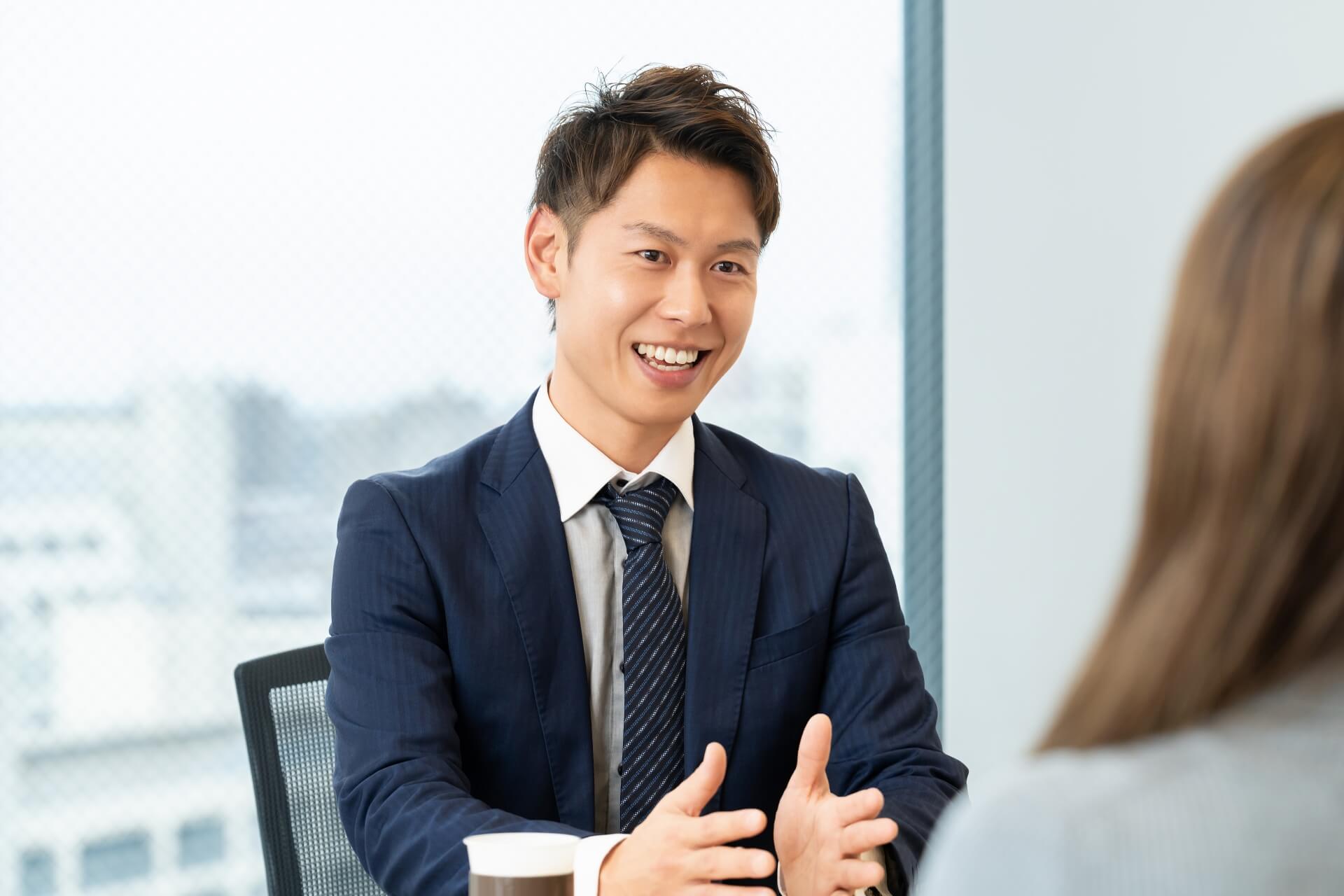 商談中に笑顔で話す若い男