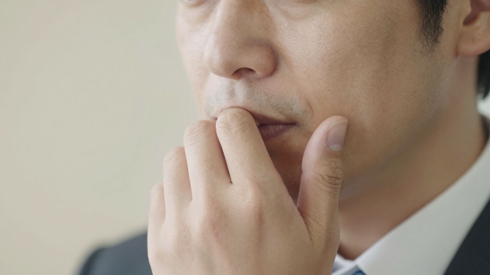 口元に指を当て考え込む表情
