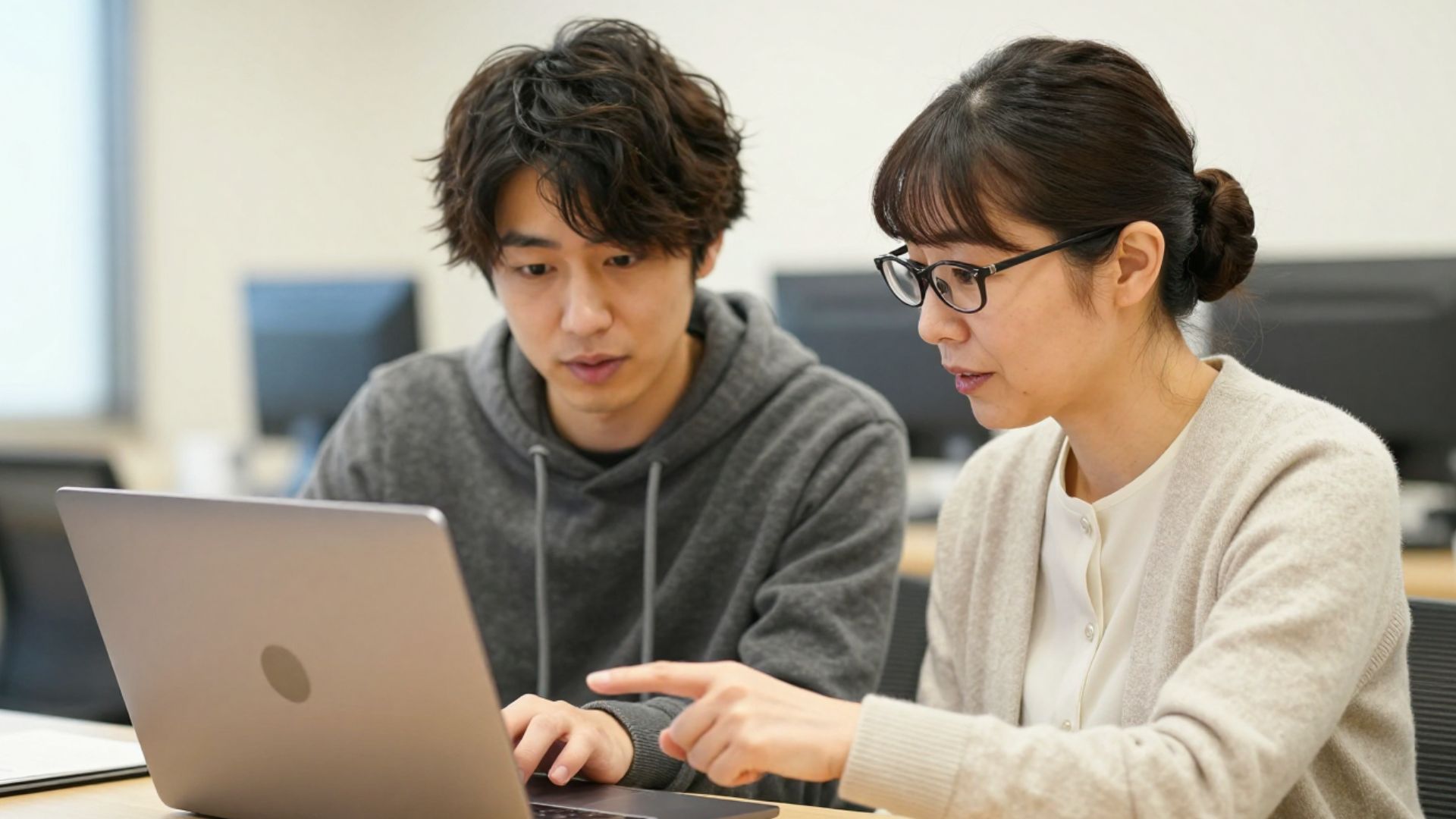 ノートPCの画面を並んで見る2人